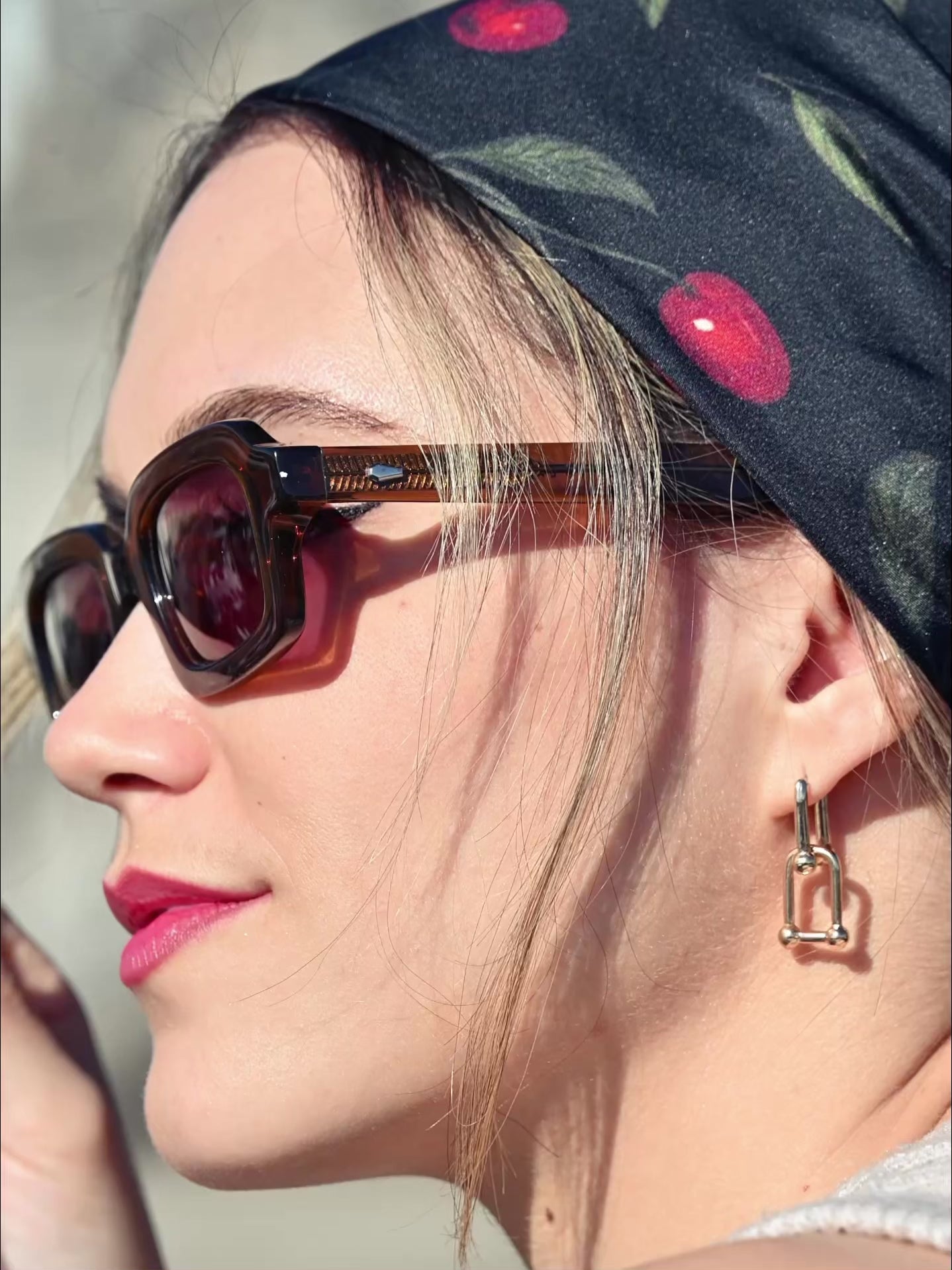 Weibliches Model trägt ein schwarzes Seidentuch mit Kirschprint als Kopftuch gebunden. Im Hintergrund ist der Eifelturm  in Paris zu sehen.